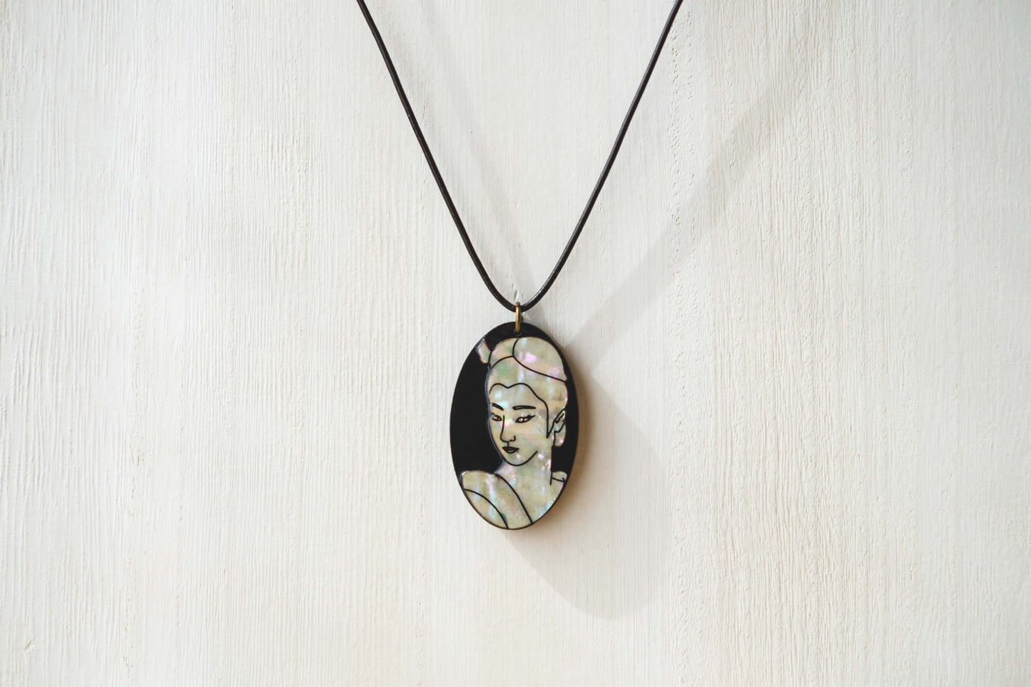 Mother of pearl necklace with engraved portrait of woman. 